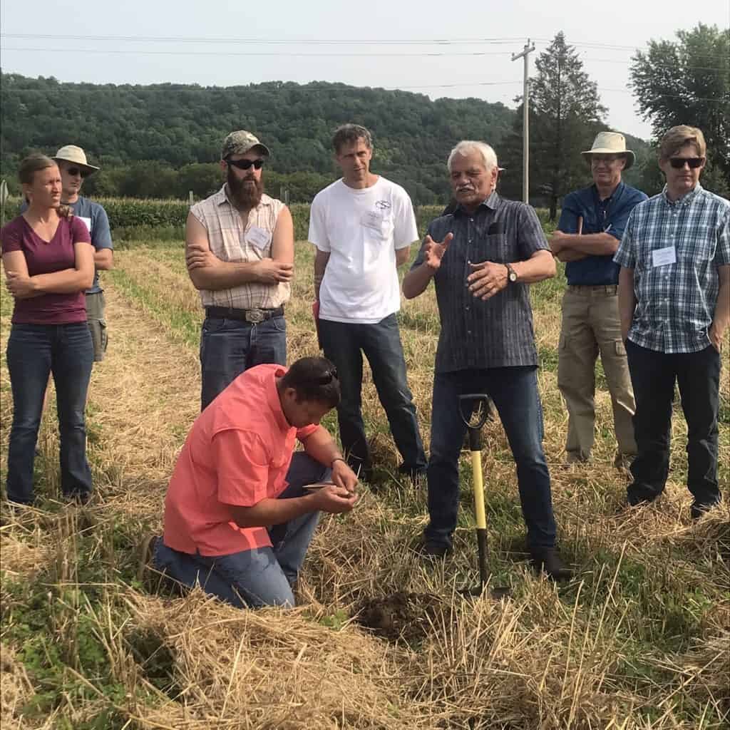 Gary Zimmer stands in cover crop field surrounded by On-Farm Intensive attendees.