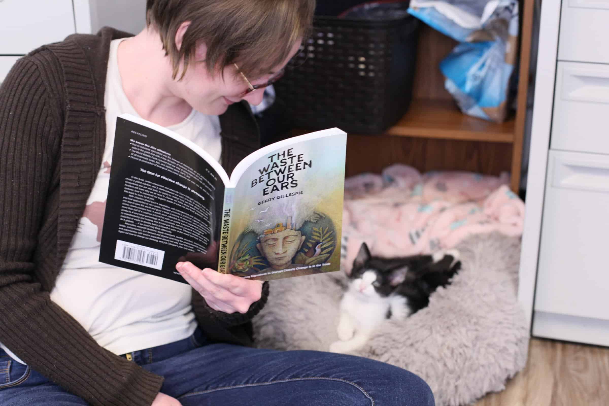 Hannah reads her book to a kitten