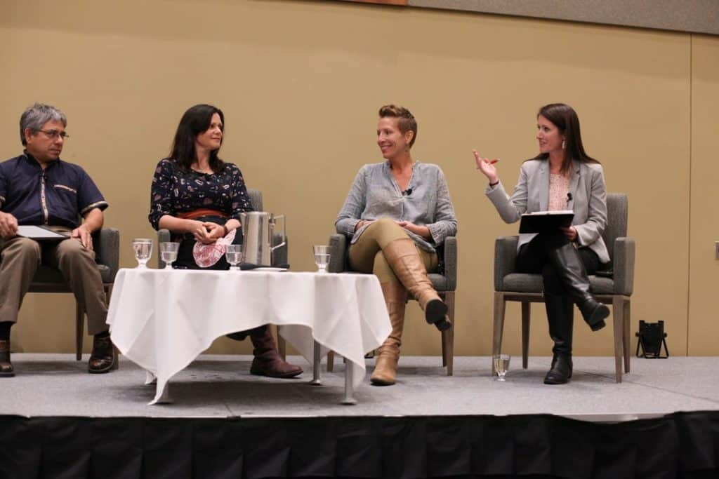 Keynote panel sits on chairs facing the audience - Reginaldo Haslett-Marroquin, Nicole Masters, Dr. Nasha Winters and moderator Sarah Day Levesque