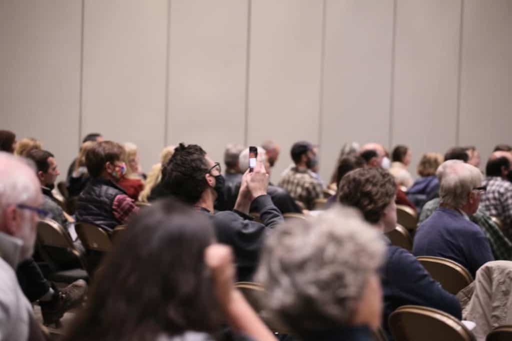 Person taking a cell phone photo of a presentation at Eco-Ag Conference.